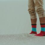 Person Wearing Red Socks Standing on Sand