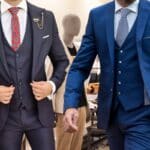 Deux hommes en costumes aux couleuses adaptées à l'hiver sortant d'un magasin de vêtement.