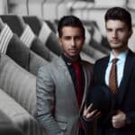 Deux hommes habillés en costume aux tendances 2024 dans un magasin de costume pour homme.