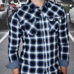 Un homme portant la chemise à carreaux, une des 8 chemises homme à avoir absolument.