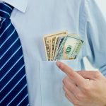 Un homme montrant l'utilité des poches de sa chemise.