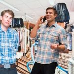 Deux amis en magasin de vêtement portant des chemises de bûcheron