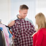 Un homme fait le choix de sa chemise à carreaux