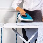 Un homme effectue le repassage d'une chemise