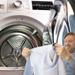 Homme secouant une chemise avant de le mettre dans un sèche-linge