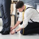 Tailleur ajustant un pantalon de costume pour homme