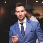 Homme en costume bleu avec un verre à la main