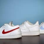 a pair of white sneakers with a red and blue nike logo